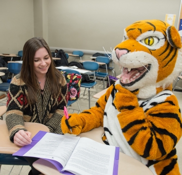 Tutor and Bengal mascot at desk