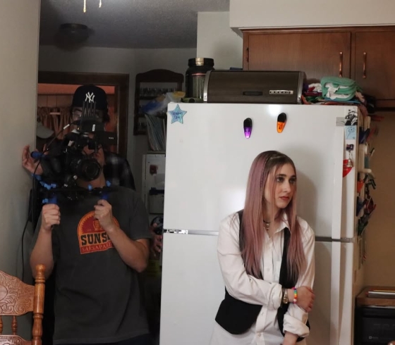 Student holding camera and student actor in scene